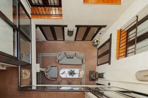 A modern interior with a sofa, a small table with a plant, and a decorative wall piece. - Suite Torre del Oro Seville: Pool, Balcony & AC in El Arenal (Sevilla)