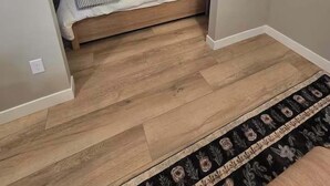 Un dormitorio con una cama de madera, una mesita de noche y un ventanal.