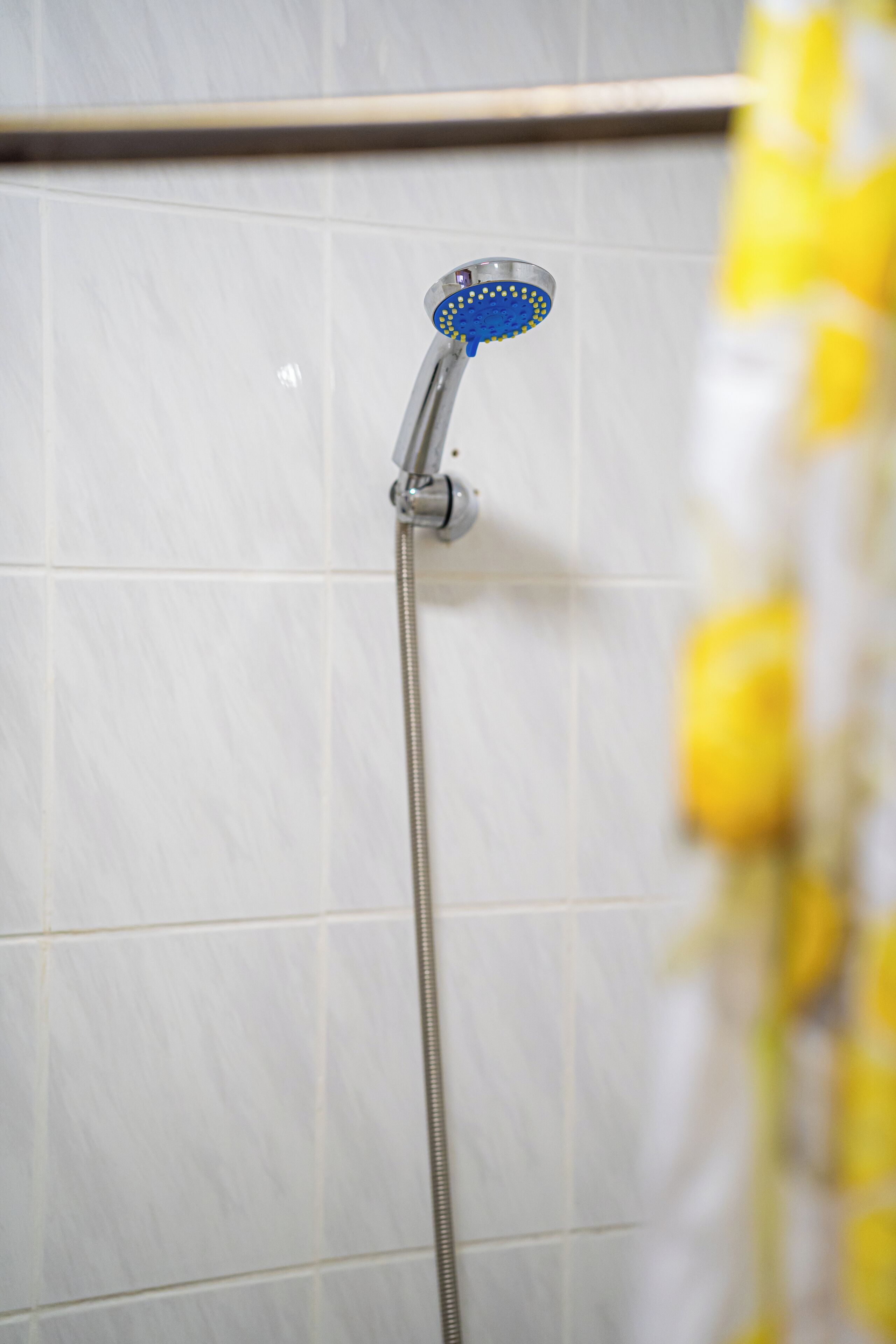 Una ducha con cabezal de ducha de mano y manguera flexible.