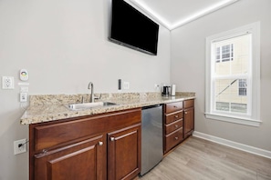 A kitchen with granite countertops, a stainless steel sink, and a dishwasher. - 5 Bdrm Home w/ Epic gameroom, pool, put put, 7 bds (North Myrtle Beach)