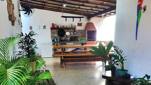 A spacious kitchen with a brick oven, wooden beams, and various kitchen appliances. - Cozy and stylish house in Alter do Chão. (Alter do Chão)