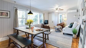A dining area with a wooden table and benches, a ceiling fan, and a view of the outdoors through large windows. - Updated, Wi-Fi, Coffee, Kitchen, Comfortable Bed (Athens)