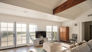 A spacious living room with a large TV, comfortable seating, and a view through the sliding glass doors. - Exceptional city light views- 5 min to Old Town (Temecula)