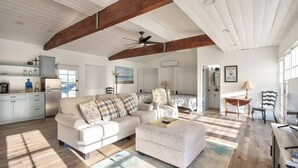 A spacious living room with a high ceiling, a large sofa, a dining area, and a kitchen with light blue cabinets. - Exceptional city light views- 5 min to Old Town (Temecula)
