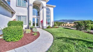 Ein modernes, zweistöckiges Haus mit gepflegtem Rasen und einer Auffahrt zur Einfahrt.