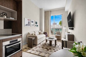 A modern living room with a sofa, coffee table, and a flat-screen TV mounted on the wall. - Domus 1BR Retreat. Short Drive to Little Havana (Miami)