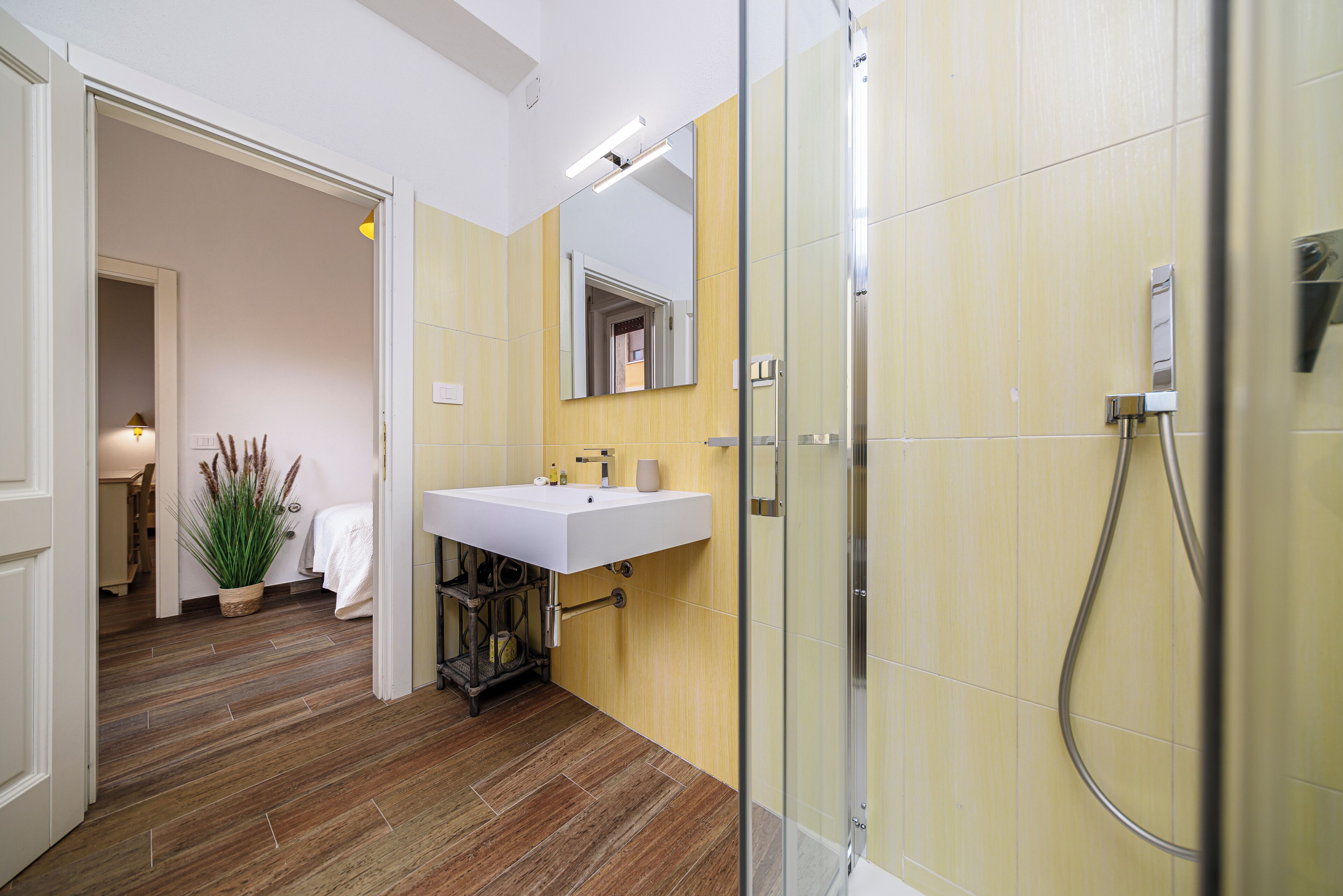 Ein Badezimmer mit Dusche, Waschbecken und Spiegel.