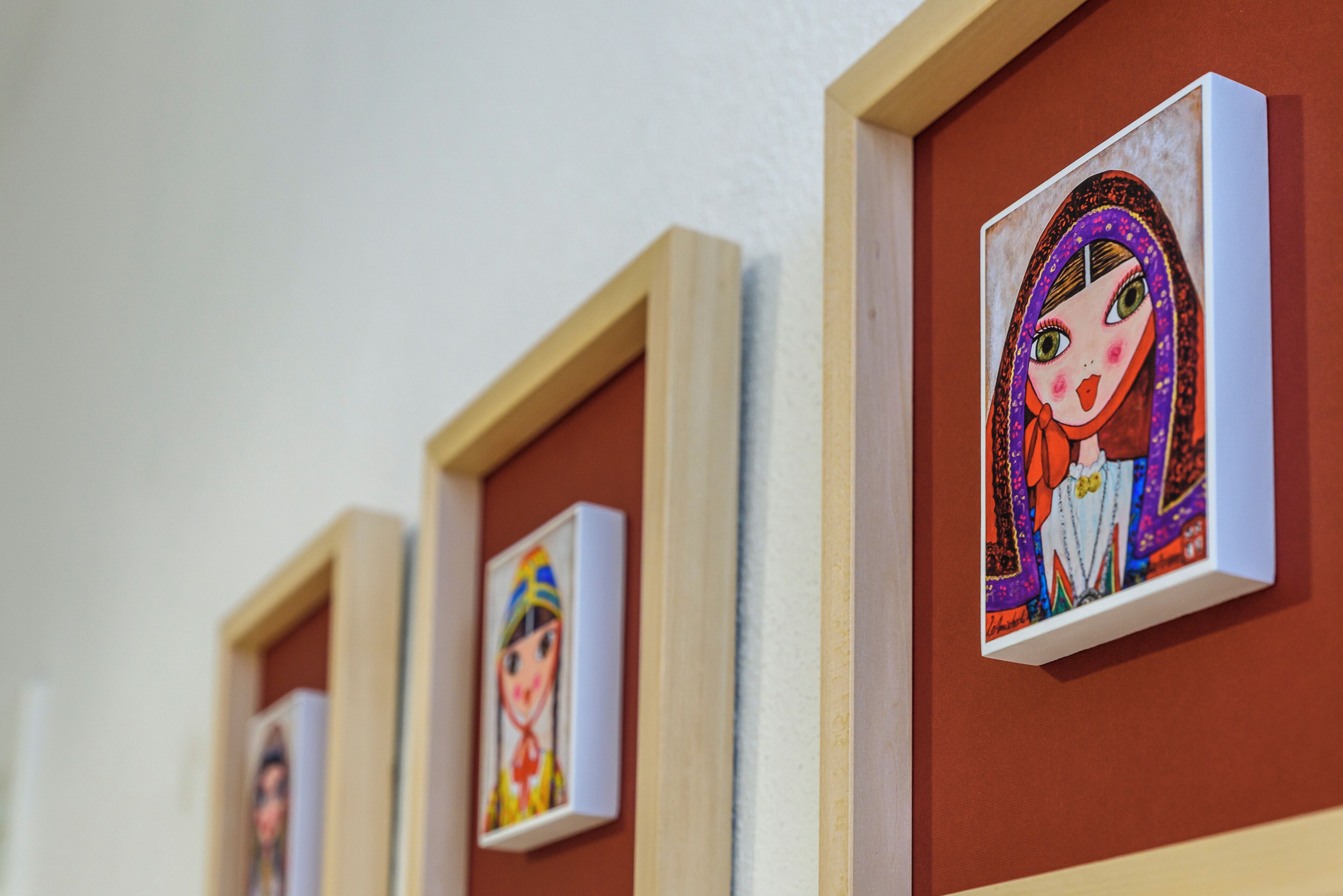 A series of framed artworks on a wall.