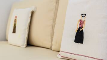 A beige sofa with two pillows, each featuring a black and red design.
