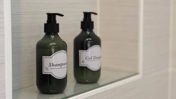 Zwei Shampooflaschen und eine Gel-Flasche auf einem Regal.