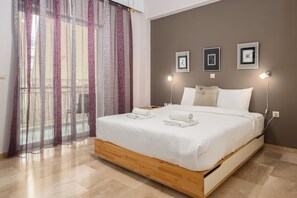 Ein Schlafzimmer mit einem Bett, Vorhängen, Wandleuchten und gerahmten Bildern.