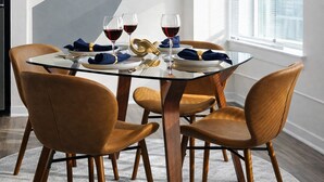 A dining area with a round table, six chairs, and two abstract paintings on the wall. - Ste 421 + Free Parking + Skywalk + Downtown 1BR Near Lucas Oil (Indianapolis)