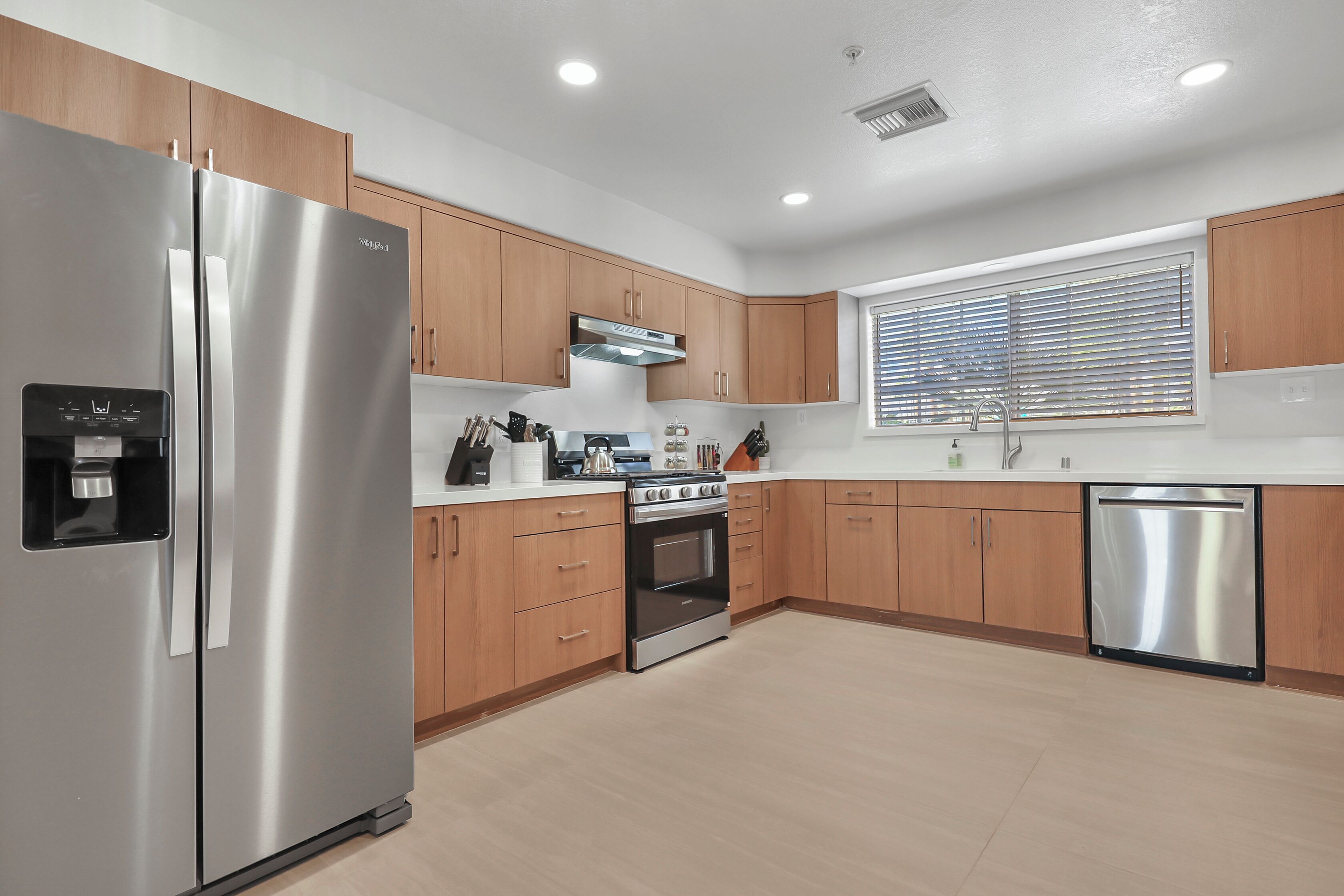 A modern kitchen with stainless steel appliances, wooden cabinets, and a built-in oven.