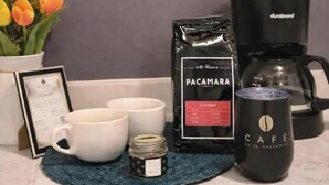 A coffee-making setup with a coffee maker, a bag of coffee, a mug, and a small jar on a kitchen counter. - Los Cipreses Hotel de Montaña (Los Naranjos)