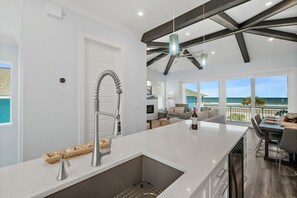 Eine moderne Küche mit einer großen Kochinsel, einer integrierten Spüle und einem Deckenventilator.
