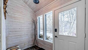 A wooden interior with a bench, two windows, and a door. - Mountain Cabin in Midway (Midway)