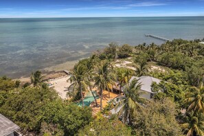 A coastal property with a beach, a pool, and a pier extending into the sea. - Serenity Bay Estate-FL Keys Best Kept Secret! Beautiful, Quiet, Tropical Pardise (Marathon)