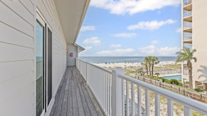 Een balkon met uitzicht op het strand en de oceaan.