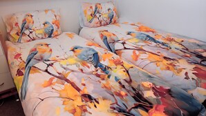 A bed with a floral print and a wooden headboard. - App 416 Panoramic Hotel Hohegeiß (Braunlage)