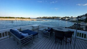 Um terraço com área de estar ao ar livre e vista para a praia e o mar.