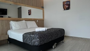 A modern hotel room with a bed, a large mirror, and a wall-mounted air conditioner. - HOTEL PISO 12 (Bello)