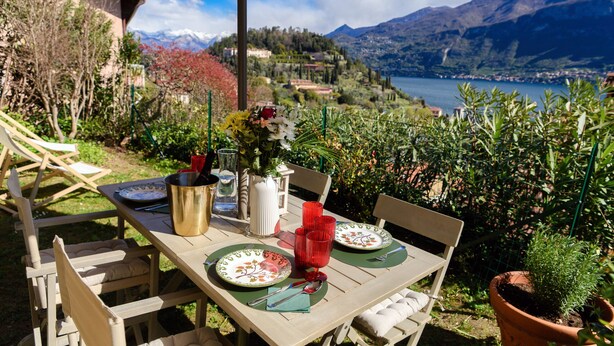 Mesa posta ao ar livre com vista para montanhas e um lago.