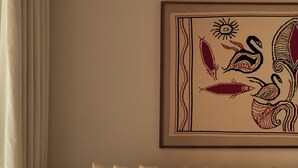 A living room with a sofa, a coffee table, and a framed artwork on the wall. - Rosewood Blue Palace (Agios Nikolaos)