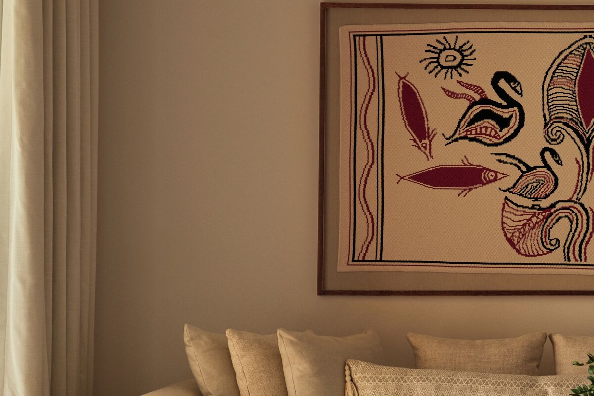 A living room with a sofa, a coffee table, and a framed artwork on the wall.