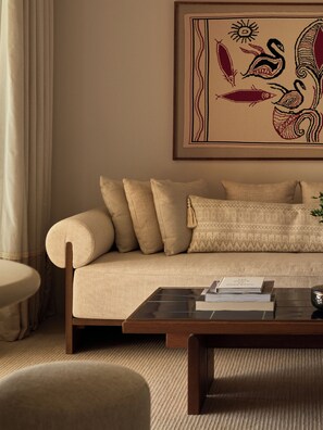 A living room with a sofa, a coffee table, and a framed artwork on the wall. - Rosewood Blue Palace (Agios Nikolaos)