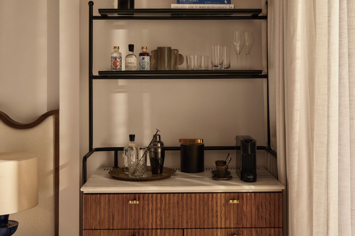 A wooden cabinet with three shelves, a vase, and a book titled 'IZNIK CERAMICS' on the top shelf.
