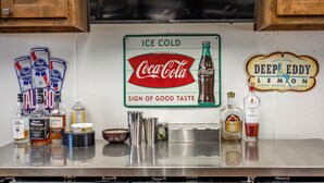 A bar area with a sign indicating 'Ice Cold' and 'Coca-Cola' with a 'Sign of Good Taste'. - Woody’s Roadhouse Retreat: Barndominium Near Lake Alan Henry (Justiceburg)