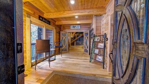 Un interno in legno con un'insegna che riporta la scritta 'Home', una scala e una poltrona in vimini.