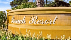 Letrero para Beach Resort con un diseño curvo y el nombre en caligrafía.