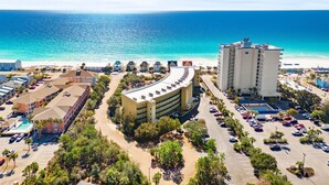 Un hotel costero con un edificio curvo, piscina y vistas al océano.