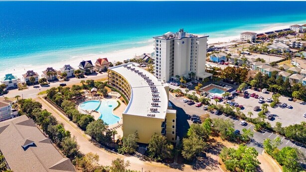 Un resort con piscina, playa y vista al océano.