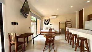 Un salon moderne avec un canapé, une table basse et un téléviseur fixé au mur.