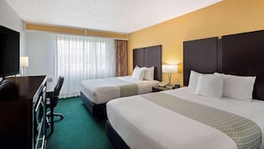 A hotel room with two beds, a desk, and a TV. - University Inn & Suites Berkeley (Berkeley)