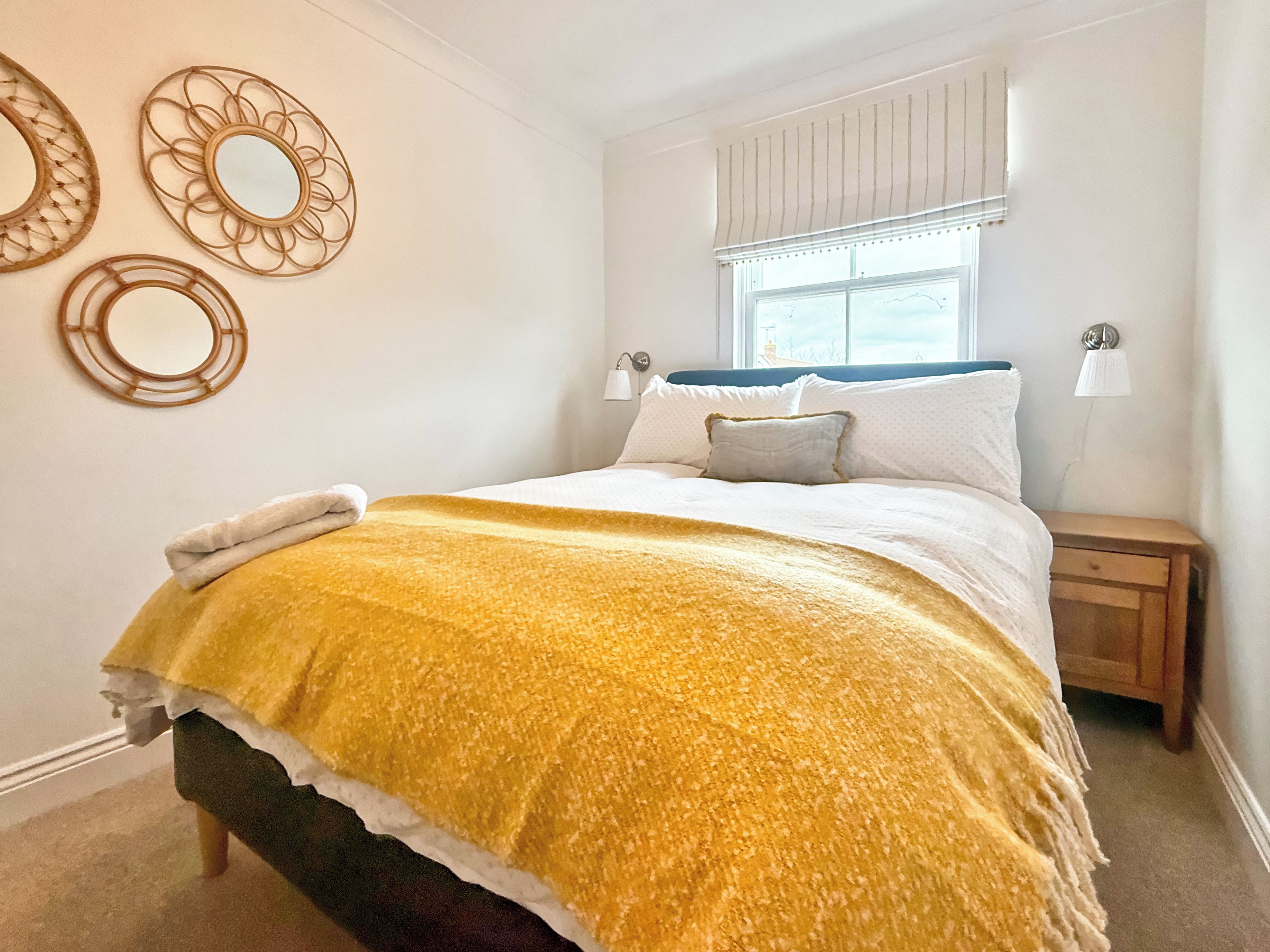 Une chambre à coucher avec un lit, des tables de chevet et des éléments de décoration murale.