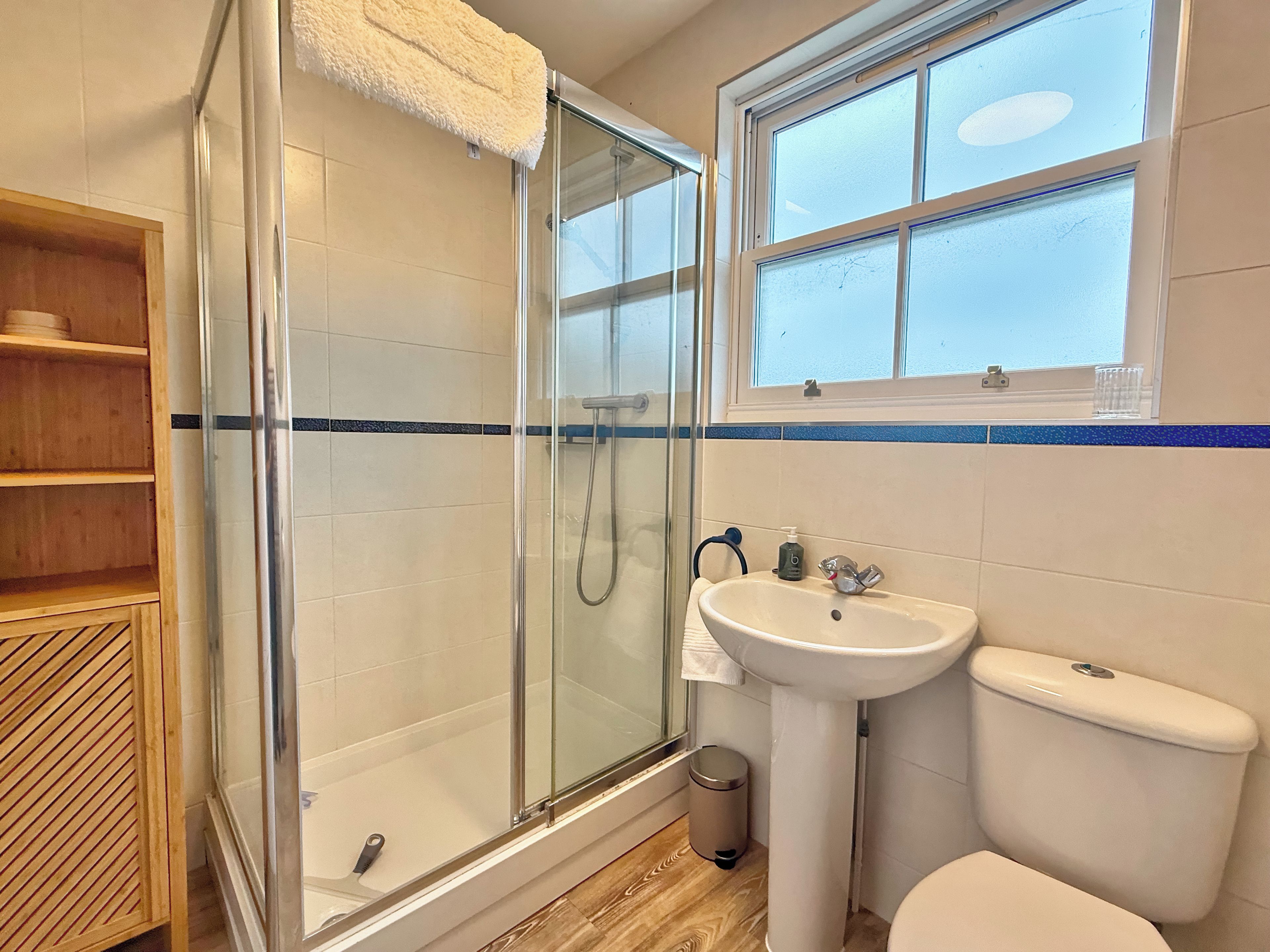 Une salle de bain avec une douche à parois de verre, un lavabo et des toilettes.
