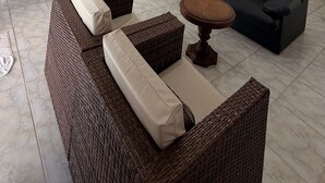 Un ampio soggiorno con soffitto alto, un divano, un tavolo da pranzo e una ventola.