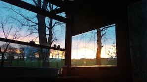 A room with a large window, a chair, and a table.
