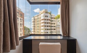 A modern room with a large window, a black console table, and a beige sofa. - Apartin a Building W/parking in Joao Paulo Boo0301 (Florianópolis)