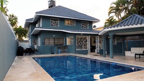 A two-story house with a swimming pool, outdoor furniture, and a covered patio area. - Private Luxury Escape  Villa Reina Bella Pool, Balcony & Sleeps 14 (Villa hermosa)