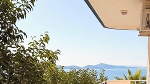 A balcony with a view of the sea and mountains, surrounded by greenery. - Alexis Beach (Pet Friendly) (Sarandë)