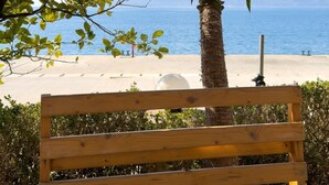 A wooden bench with a view of the sea and a palm tree. - Alexis Beach (Pet Friendly) (Sarandë)