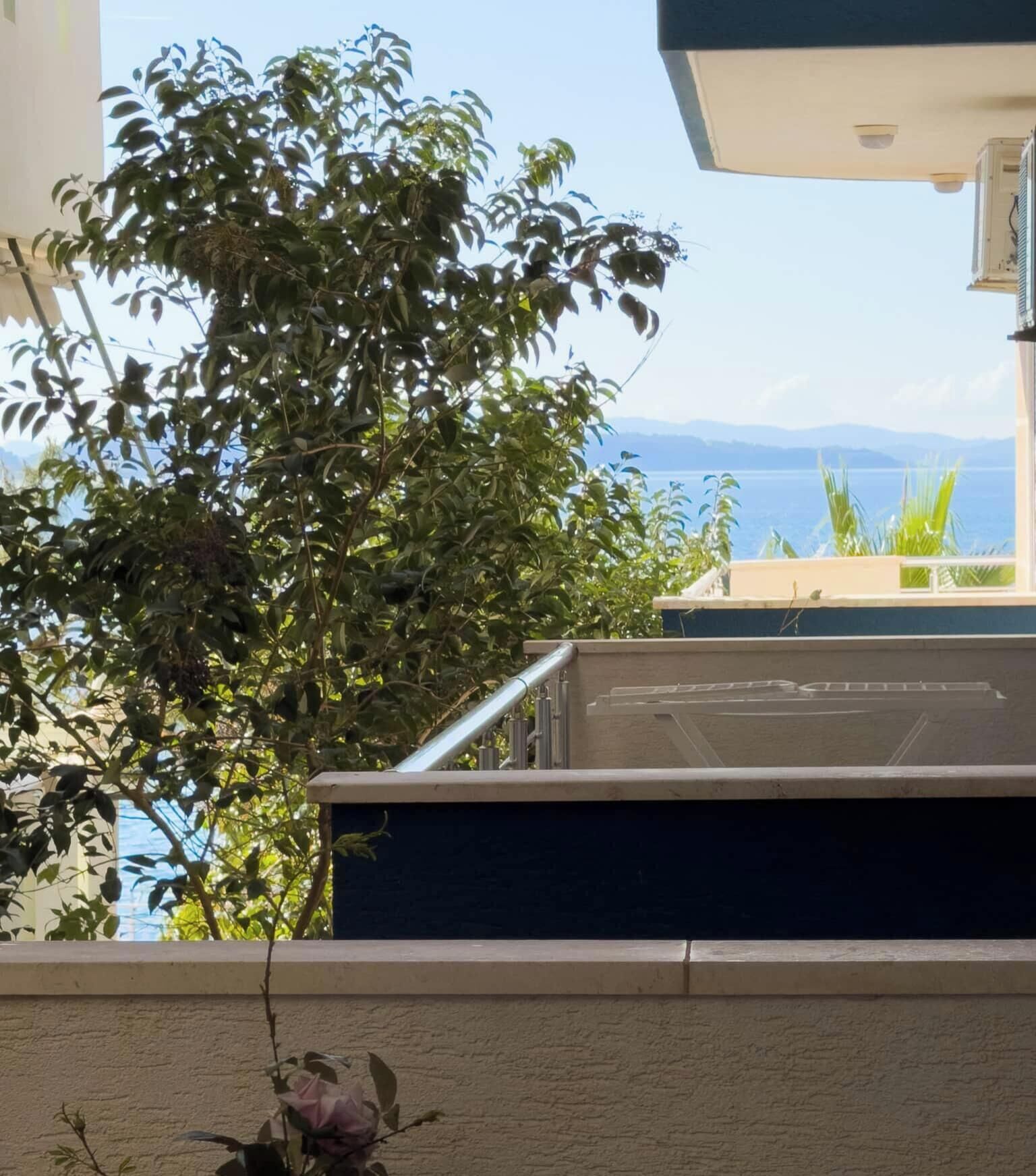 A balcony with a view of the sea and mountains.