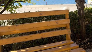 A wooden bench with a view of a beach and palm trees. - Amelia Beach (Pet Friendly) (Sarandë)