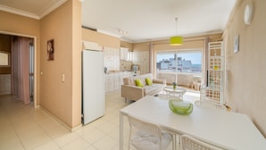 Um apartamento moderno com cozinha, sala de jantar e varanda com vista para a cidade.