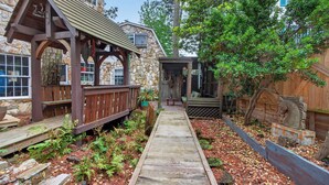 A wooden pathway leading to a stone building with a wooden deck and a stone wall. - 401 142nd Street (Ocean City)