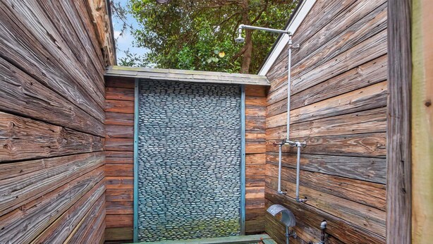 A wooden cabin with a stone wall, a shower, and a metal pipe. - 401 142nd Street (Ocean City)
